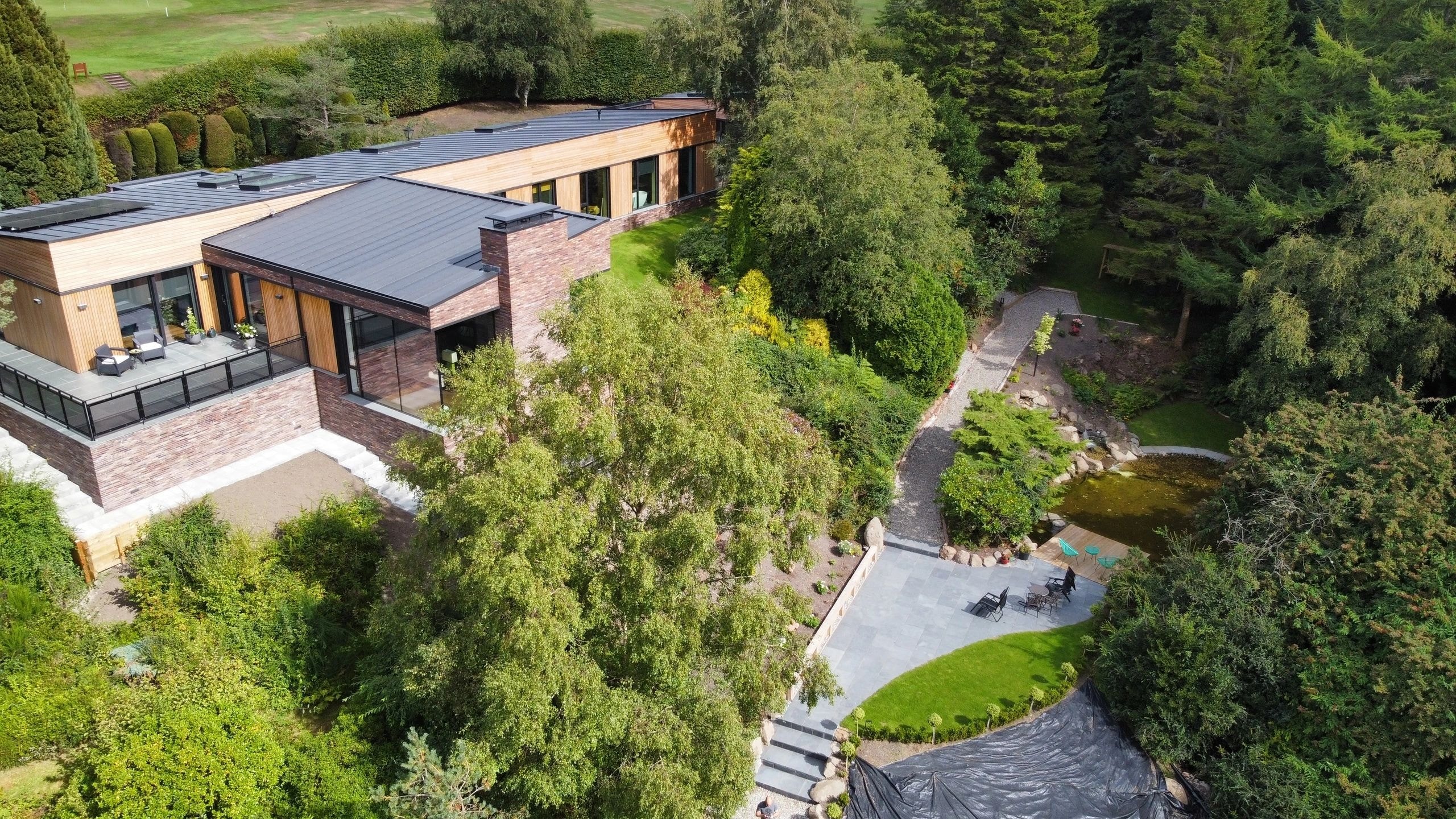 Aerial view of house nestled in forest landscape